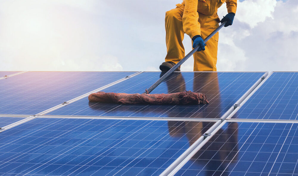 person cleaning solar panel